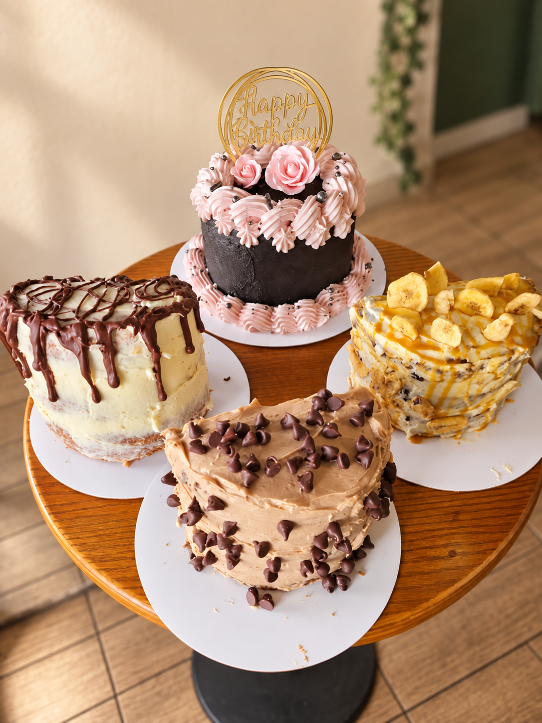 Four Mamá Inca celebration cakes with chocolate, fruit, and pink frosting decorations
